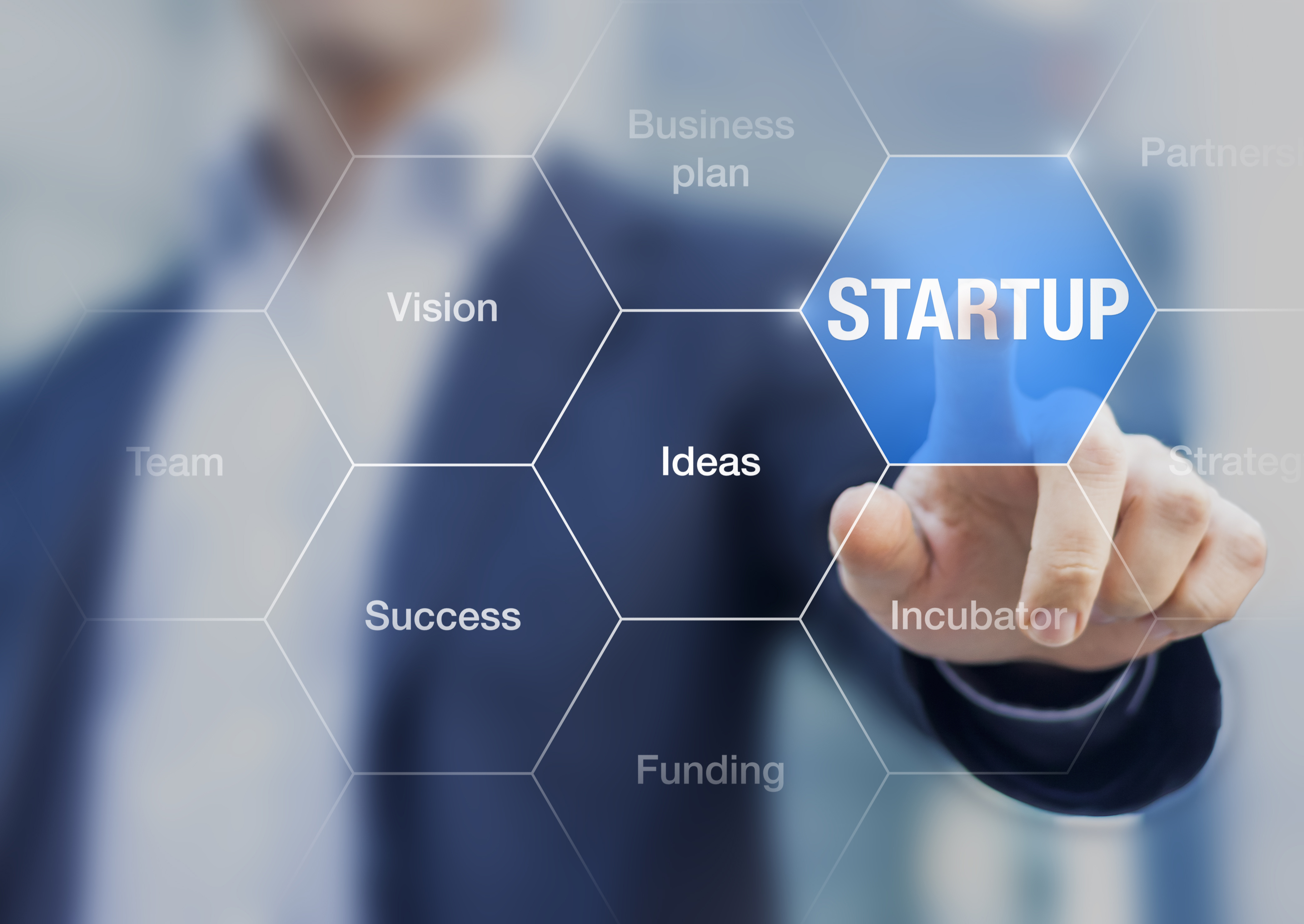 Startup button on a virtual screen touched by a businessman